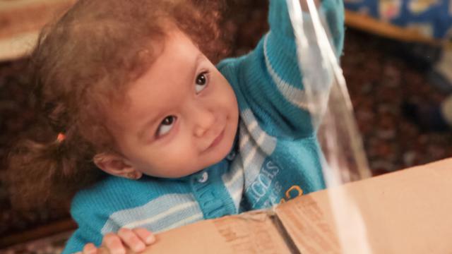 Little girl open a box