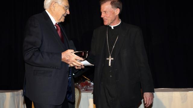 L. Tom Perry elder humnitárius elismerést vesz át 2014. november 6-án a Salt Lake City-i katolikus egyházmegye püspökétol, John C. Westertol