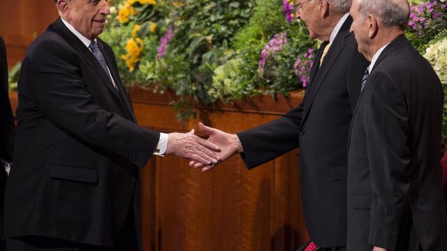 Thomas S. Monson elnök kezet ráz Perry elderrel a 2013. áprilisi általános konferencia egyik szünetében